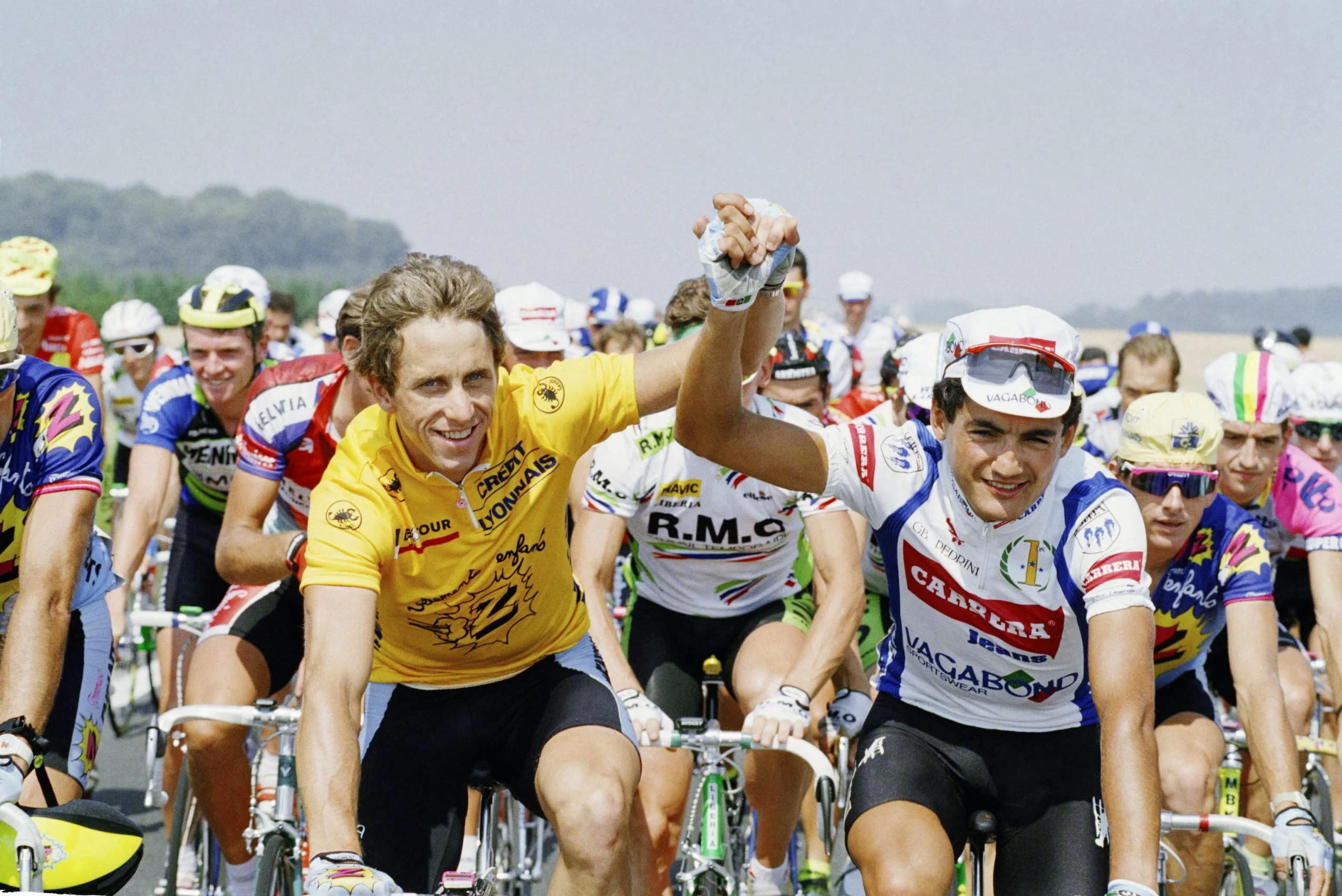 Defending champion Greg LeMond of the United States, left, grasps hands with Claudio Chiappucci of Italy going into the final stage of the Tour de France, Sunday, July 22, 1990, Paris, France. LeMond won his third Tour de France Sunday and Chiappucci finished second. (AP Photo/Laurent Rebours)