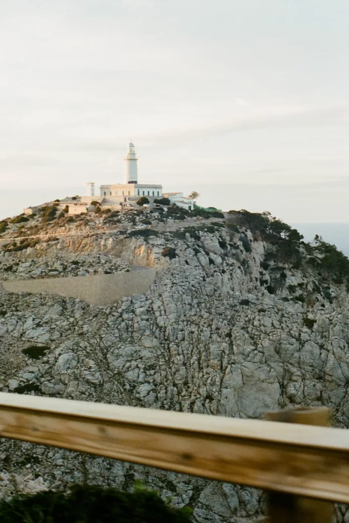 white lighthouse on brown rocky mountain during daytime cap formentor