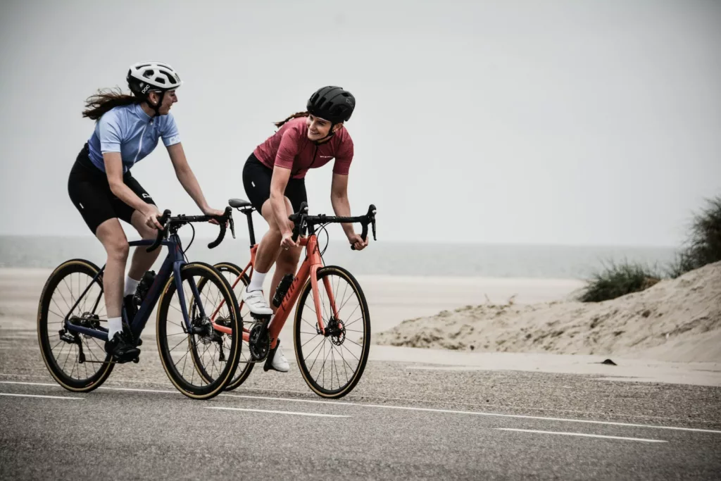 man and woman riding road bikes at the road near shore cycling speed