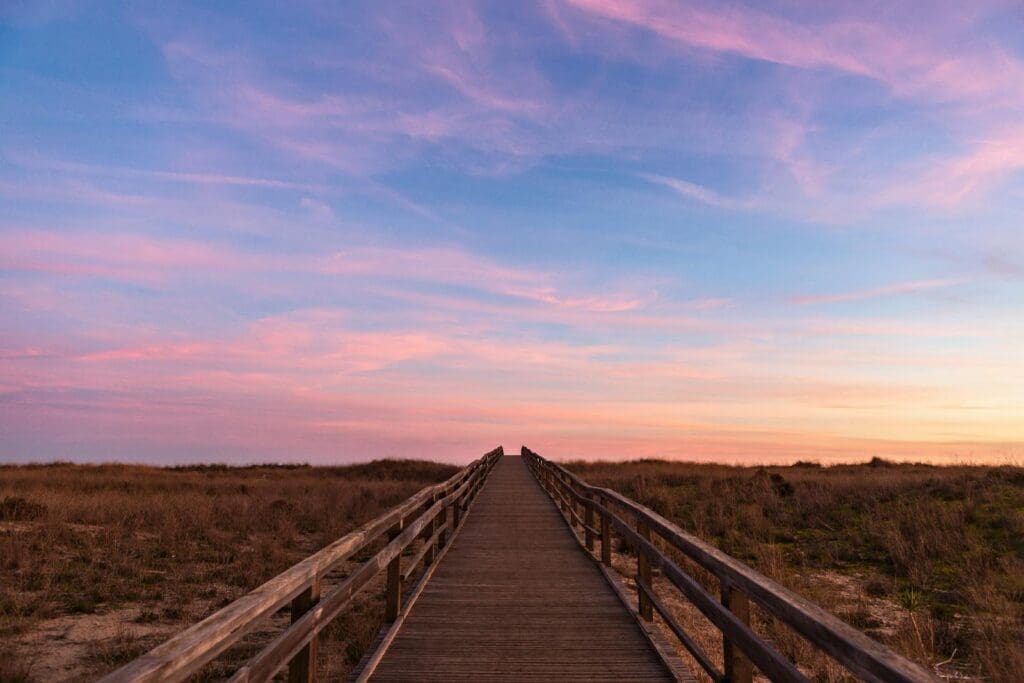 algarve Experience tranquility as the sun sets over a scenic boardwalk in Lagos, Portugal.