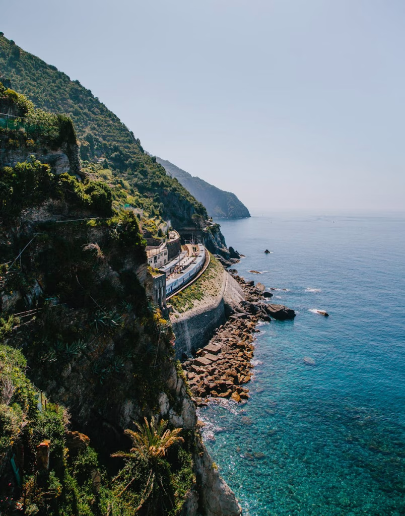 Stunning cliffside view along the Ligurian coast with lush greenery and azure sea in Liguria, Italy.