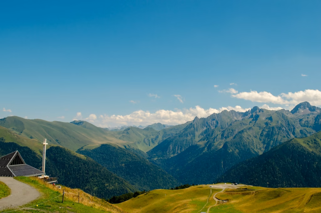 green grass field and mountains under blue sky during daytime