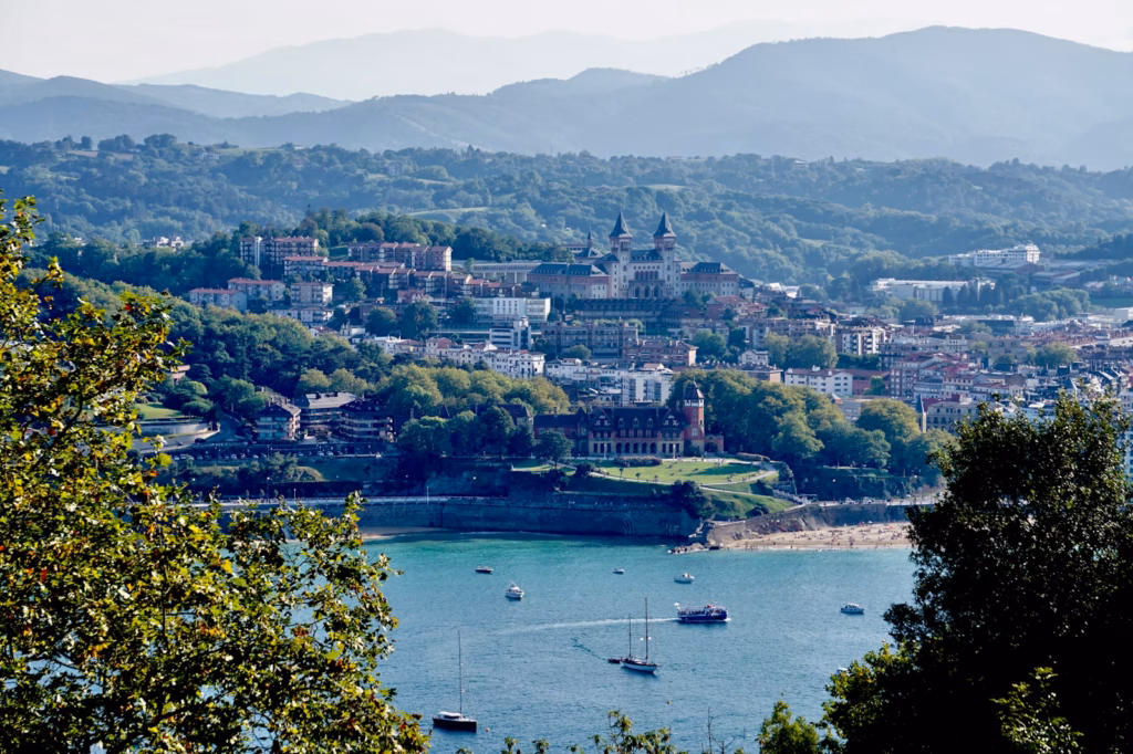 a view of a city and a lake with boats in the water san sebastian