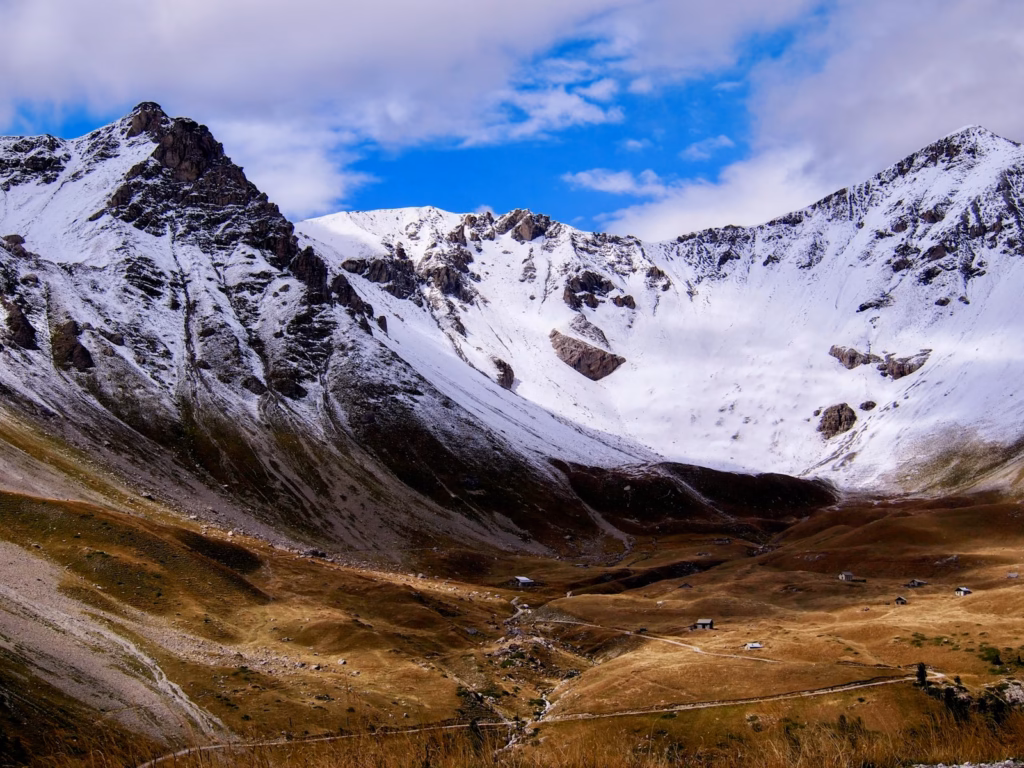 a snow covered mountain with a wire fence in the foreground