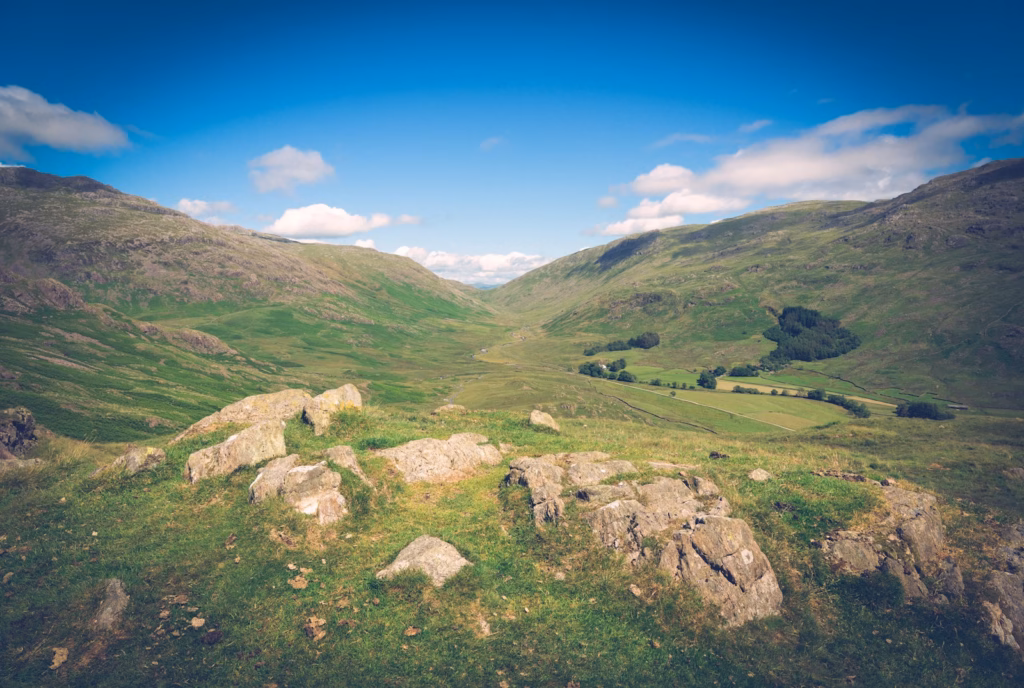 a grassy hill with rocks Hardknott Pass