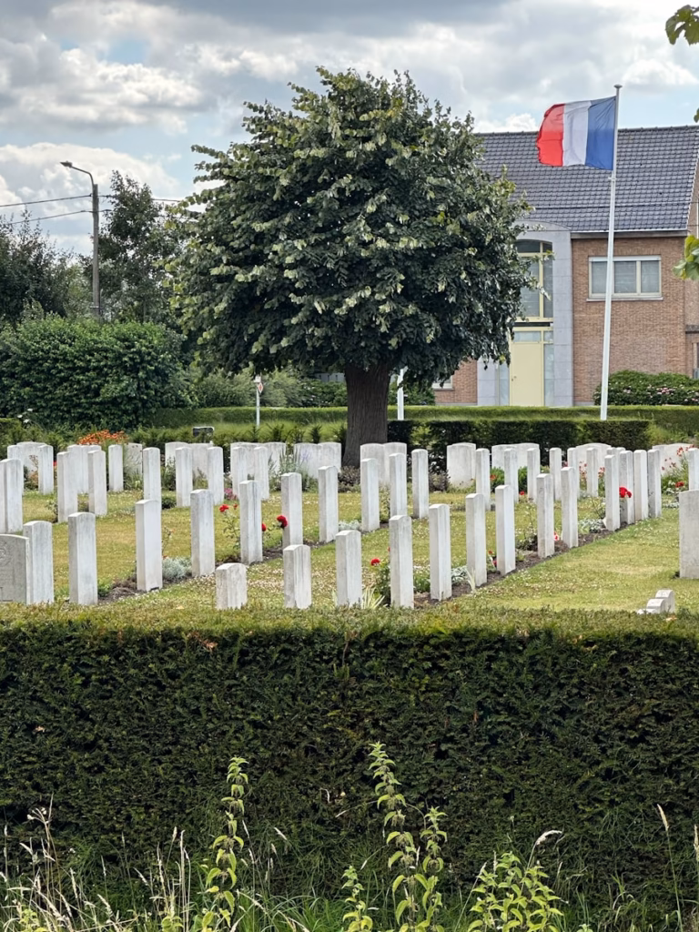 Ypres A french cemetery with a flag and tombstones.