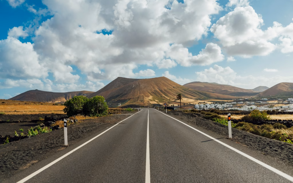 Lanzarote gray asphalt road near brown mountain under white clouds and blue sky during daytime