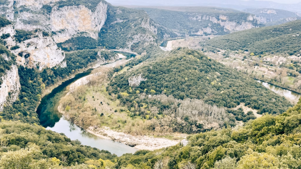 Ardeche France a river flowing through a lush green valley