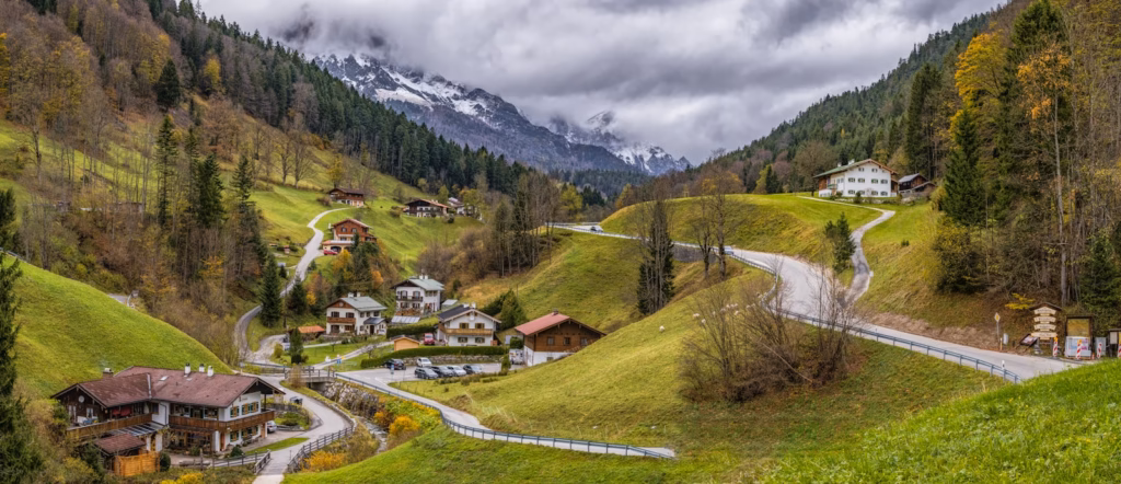 Bavaria Alps houses on green mountain surrounded with trees