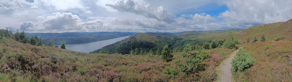 Loch Ness A scenic landscape with a lake and rolling hills.