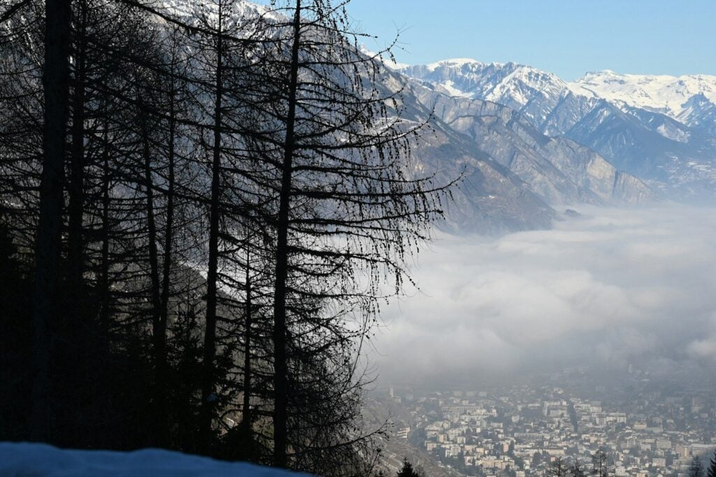Martigny a view of a city below a mountain covered in snow