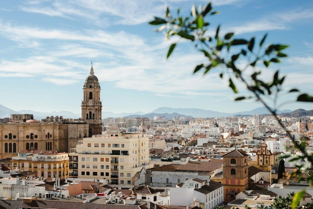 Malaga a view of a city with tall buildings and a clock tower