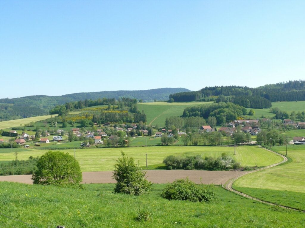 Vosges Rural village nestled among rolling green hills and fields.