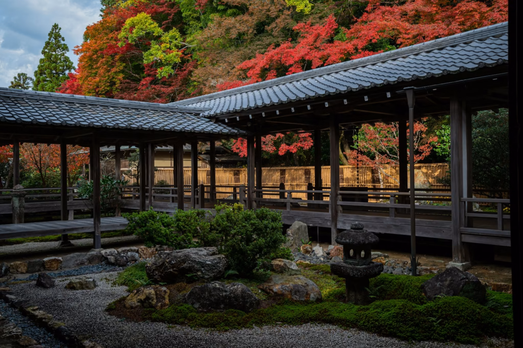 Kyoto A wooden covered walkway in a Japanese garden with vibrant autumn foliage